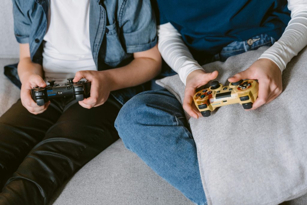 Person in White Long Sleeve Shirt and Blue Denim Jeans Holding Brown and Black Toy Gun